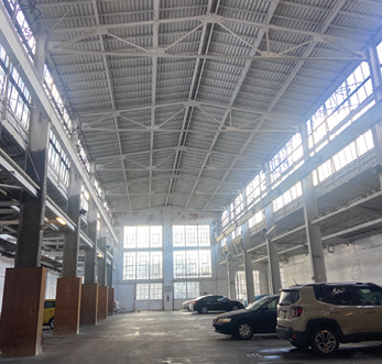 Inside the converted parking garage bays under a steel truss roof